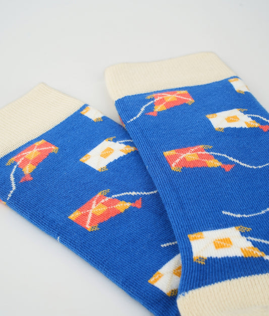 Chaussettes fantaisie bleu roi et crème en coton biologique à motif de cerfs-volants. Fabriquées en Europe, elles offrent un confort optimal grâce à leurs zones renforcées et leurs finitions plates sans couture.