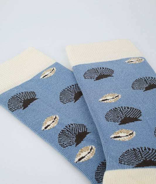 Chaussettes fantaisie bleues à motif de coquillages beige, inspirées des trésors du littoral. Fabriquées en Europe en coton biologique, elles allient confort, douceur et une touche marine originale au quotidien.