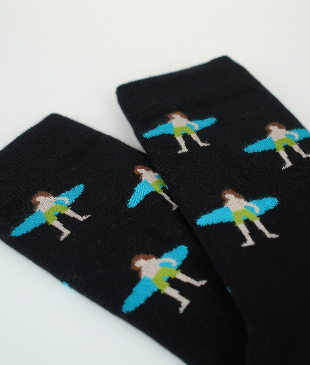 Chaussettes fantaisie noires à motif de surfeurs. Fabriquées en Europe en coton biologique, elles offrent confort, douceur et résistance pour un style décontracté.
