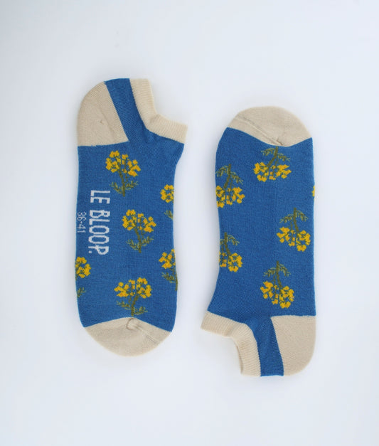 Socquettes fantaisie bleues à motif de fleurs immortelles. Confectionnées en Europe en coton biologique, elles offrent une sensation de douceur et un style floral inspiré de la nature.