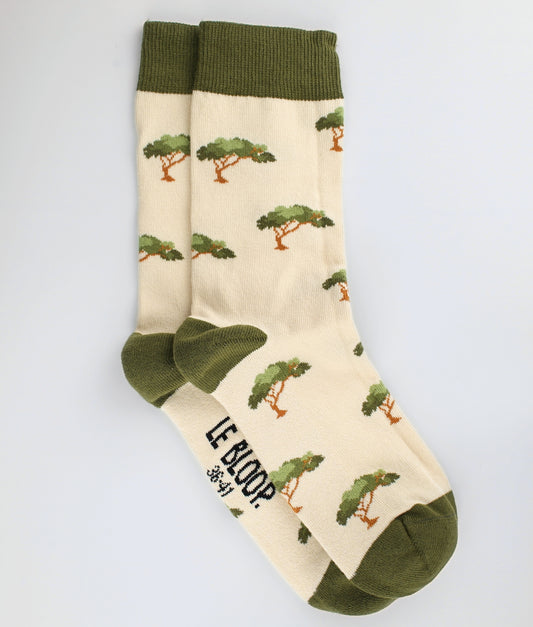 Chaussettes fantaisie beige et kaki en coton biologique à motif de pins et de parasol. Fabriquées en Europe, elles offrent un confort optimal grâce à leurs zones renforcées et leurs finitions plates sans couture.