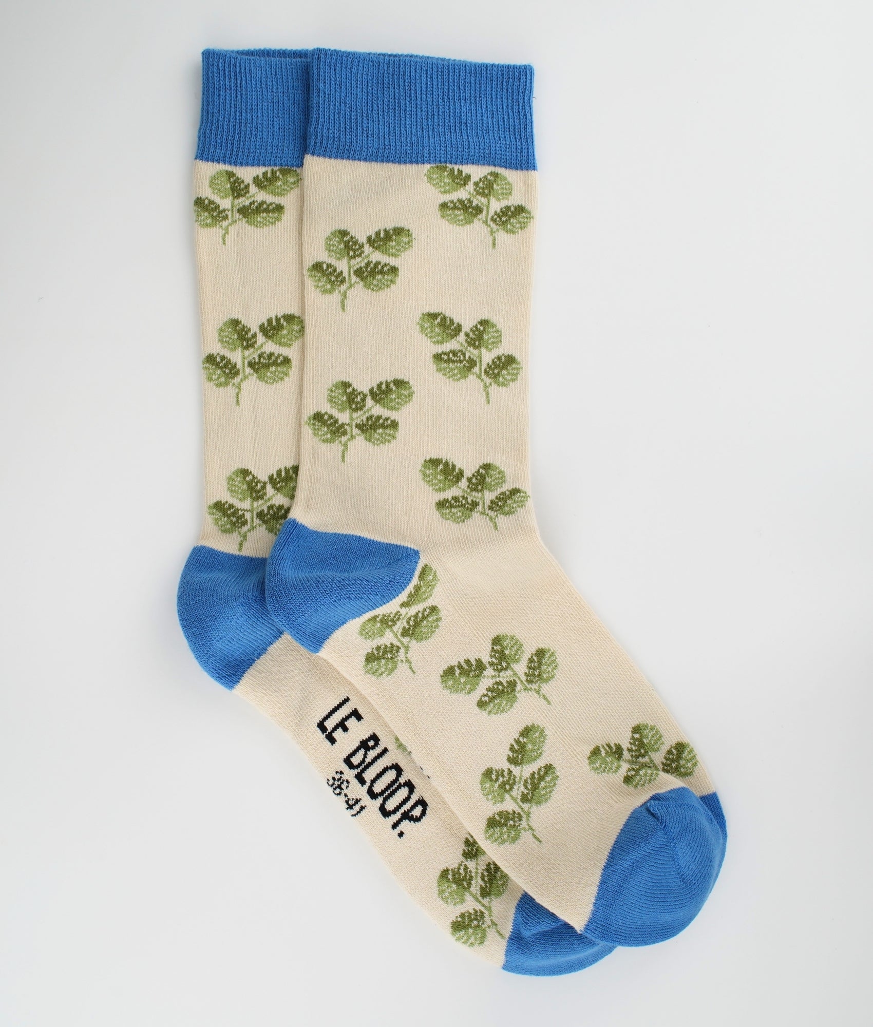 Chaussettes fantaisie beiges et bleues en coton biologique à motif de feuilles de Monstera. Fabriquées en Europe, elles offrent un confort optimal grâce à leurs zones renforcées et leurs finitions plates sans couture.