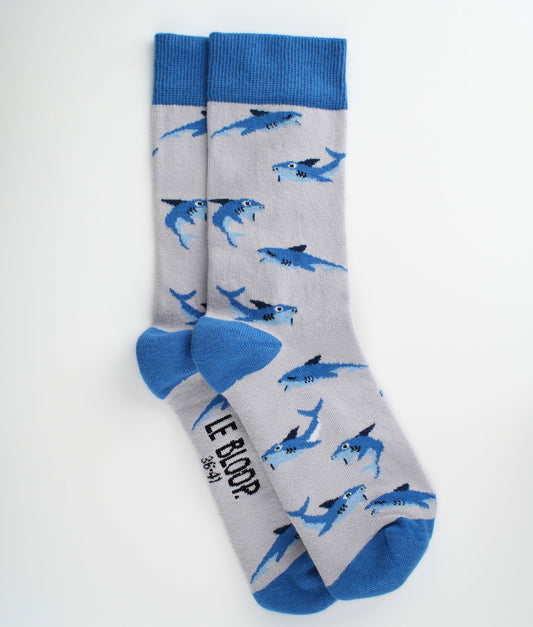 Chaussettes fantaisie bleues à motif de requins. Confectionnées en Europe en coton biologique, elles allient confort, qualité et inspiration marine pour accompagner toutes vos tenues.