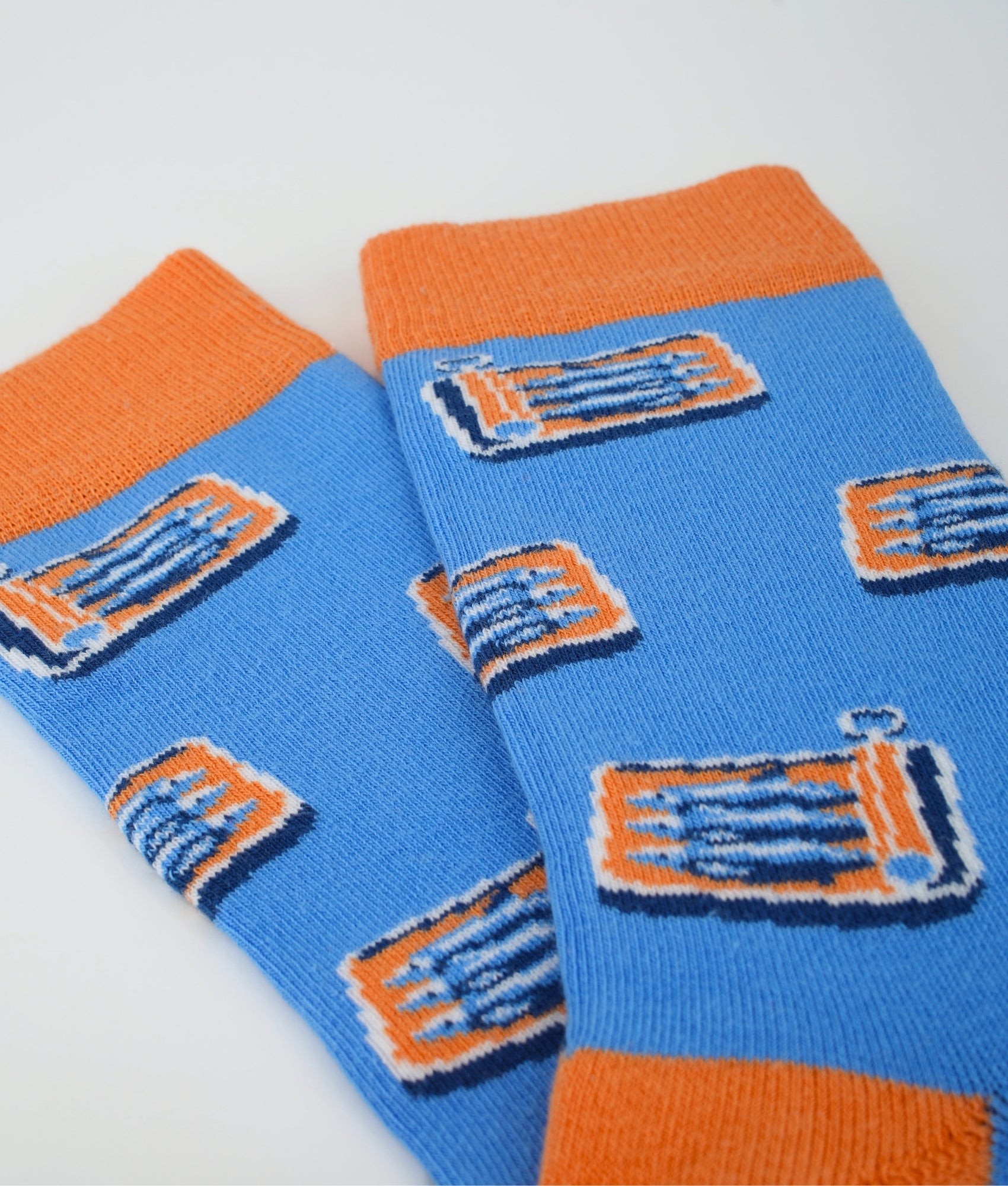 Chaussettes fantaisie bleues en coton biologique à motif de boîtes de sardines. Fabriquées en Europe, elles offrent un confort optimal grâce à leurs zones renforcées et leurs finitions plates sans couture.