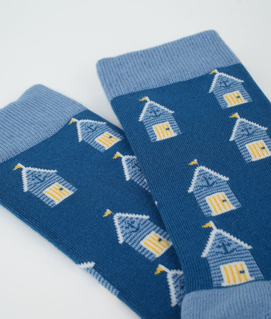 Chaussettes fantaisie bleues en coton biologique à motif de cabines de plage. Fabriquées en Europe, elles offrent un confort optimal grâce à leurs zones renforcées et leurs finitions plates sans couture.