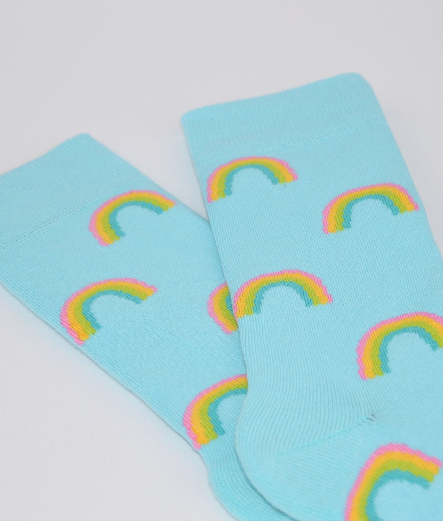 Chaussettes fantaisie bleues turquoise à motif arc-en-ciel coloré, en coton biologique, fabriquées au Portugal, confortables et résistantes.