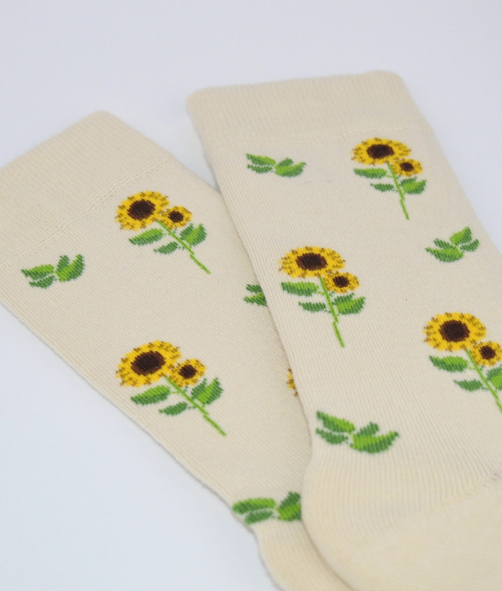 Chaussettes fantaisie crème et jaunes à motif tournesols, en coton biologique, fabriquées au Portugal, confortables et résistantes.