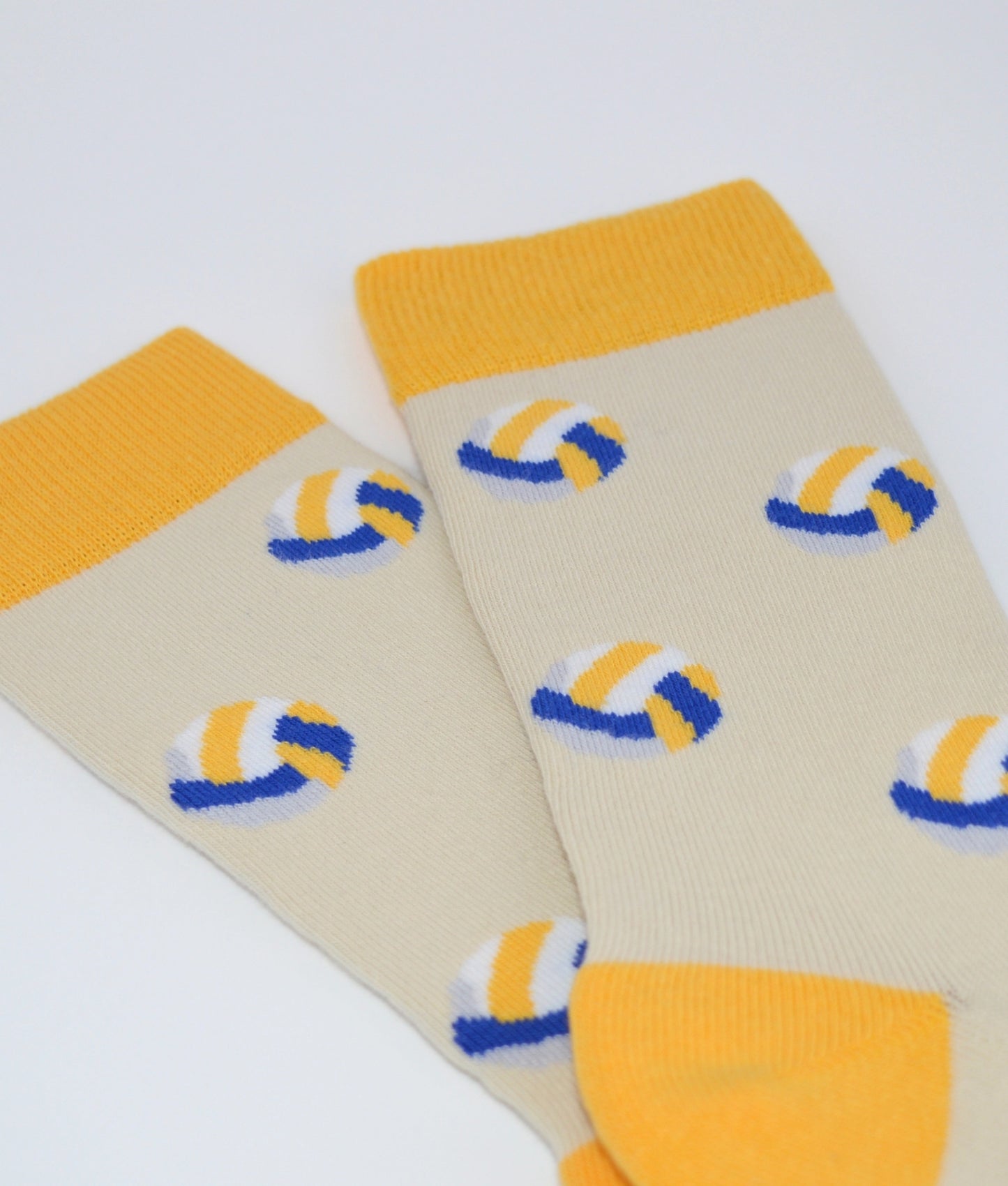 Chaussettes fantaisie crème et jaune à motif ballon de volley, en coton biologique, fabriquées au Portugal, confortables et résistantes.