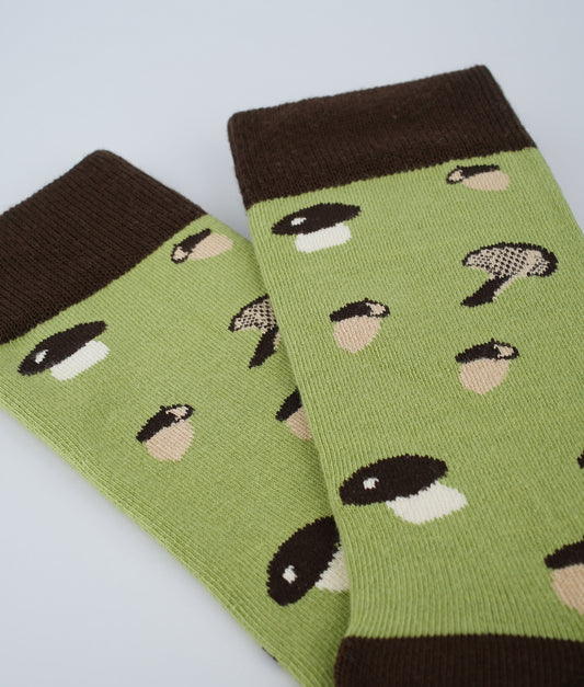 Chaussettes fantaisie vertes à motif de champignons et de glands.