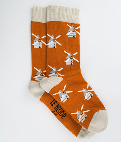Chaussettes fantaisie orange à motif de moulins à vent. Tricotées en Europe en coton biologique, elles offrent un confort durable grâce à leurs renforts au talon et à la pointe ainsi qu'à leurs finitions plates sans couture.