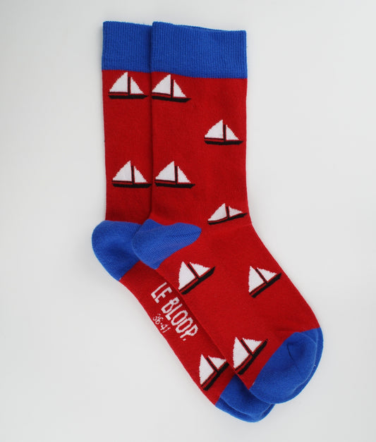 Chaussettes fantaisie rouges et bleues à motif de voiliers. Fabriquées en Europe en coton biologique, elles allient confort, douceur et style marin au quotidien.