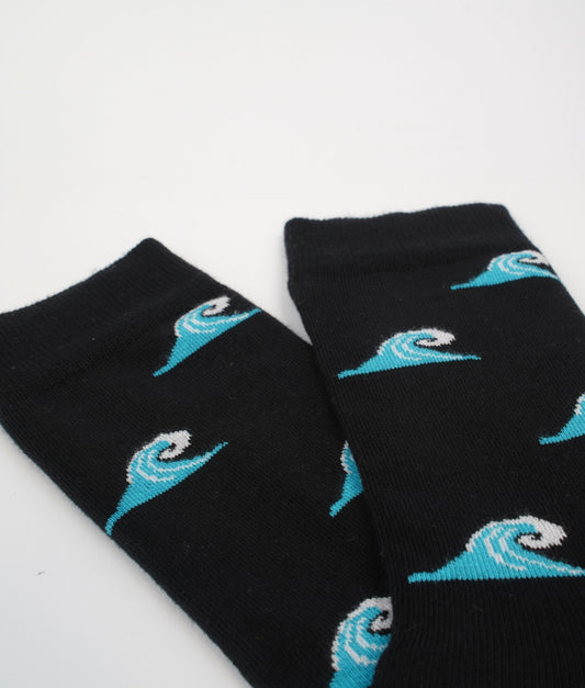 Chaussettes fantaisie noires à motif de vagues de surf, inspirées de l’océan et de l’esprit des plages atlantiques. Fabriquées en Europe en coton biologique, elles allient confort, douceur et originalité au quotidien.