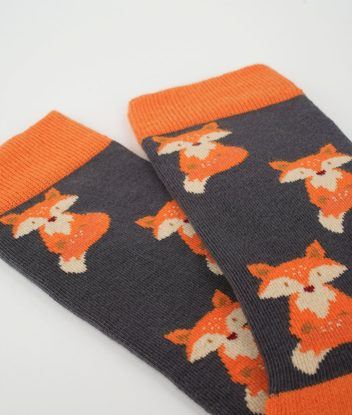 Chaussettes fantaisie orange à motif de renards. Fabriquées en Europe en coton biologique, elles apportent une touche chaleureuse et originale tout en offrant confort et douceur au quotidien.