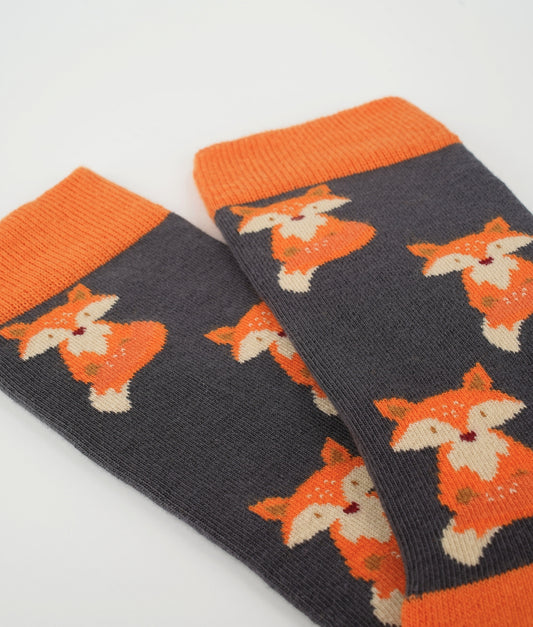 Chaussettes fantaisie orange à motif de renards. Fabriquées en Europe en coton biologique, elles apportent une touche chaleureuse et originale tout en offrant confort et douceur au quotidien.