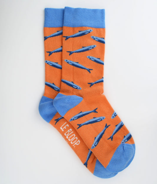 Chaussettes fantaisie orange en coton biologique à motif de sardines bleues. Fabriquées en Europe, elles offrent un confort optimal grâce à leurs zones renforcées et leurs finitions plates sans couture.