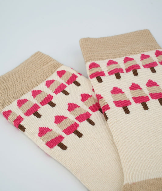 Chaussettes fantaisie roses et crème en coton biologique à motif de glaces. Fabriquées en Europe, elles offrent un confort optimal grâce à leurs zones renforcées et leurs finitions plates sans couture.