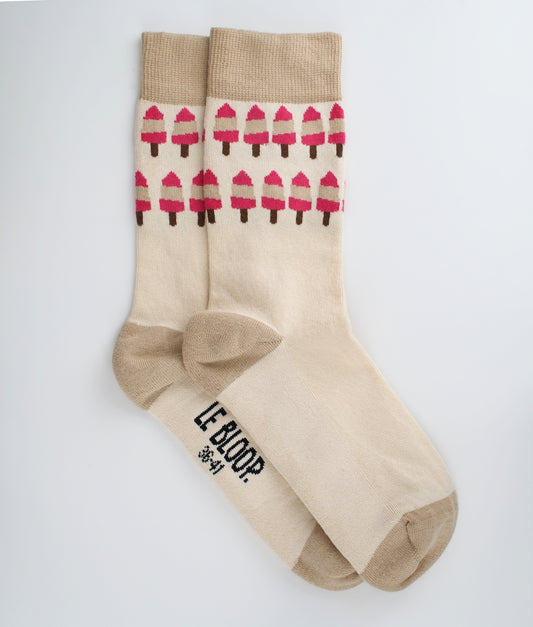 Chaussettes fantaisie roses et crème en coton biologique à motif de glaces. Fabriquées en Europe, elles offrent un confort optimal grâce à leurs zones renforcées et leurs finitions plates sans couture.