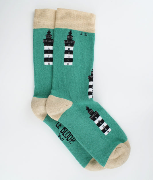 Chaussettes fantaisie en coton biologique à motif de phares du bord de mer. Fabriquées en Europe, elles offrent un confort optimal grâce à leurs zones renforcées et leurs finitions plates sans couture.