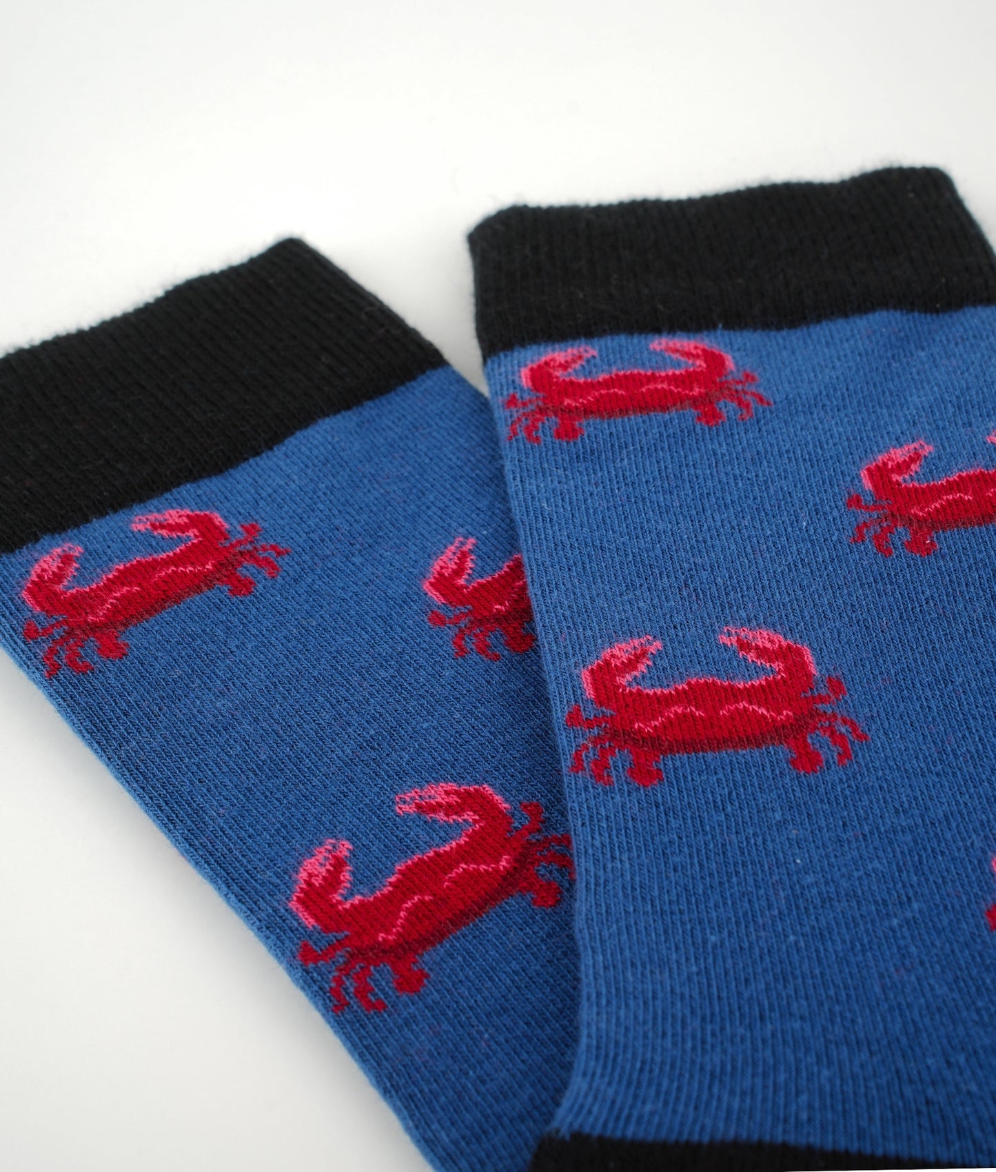 Chaussettes fantaisie bleues à motif de crabes rouges. Fabriquées en Europe en coton biologique, elles allient confort, douceur et originalité pour un style marin plein de caractère
