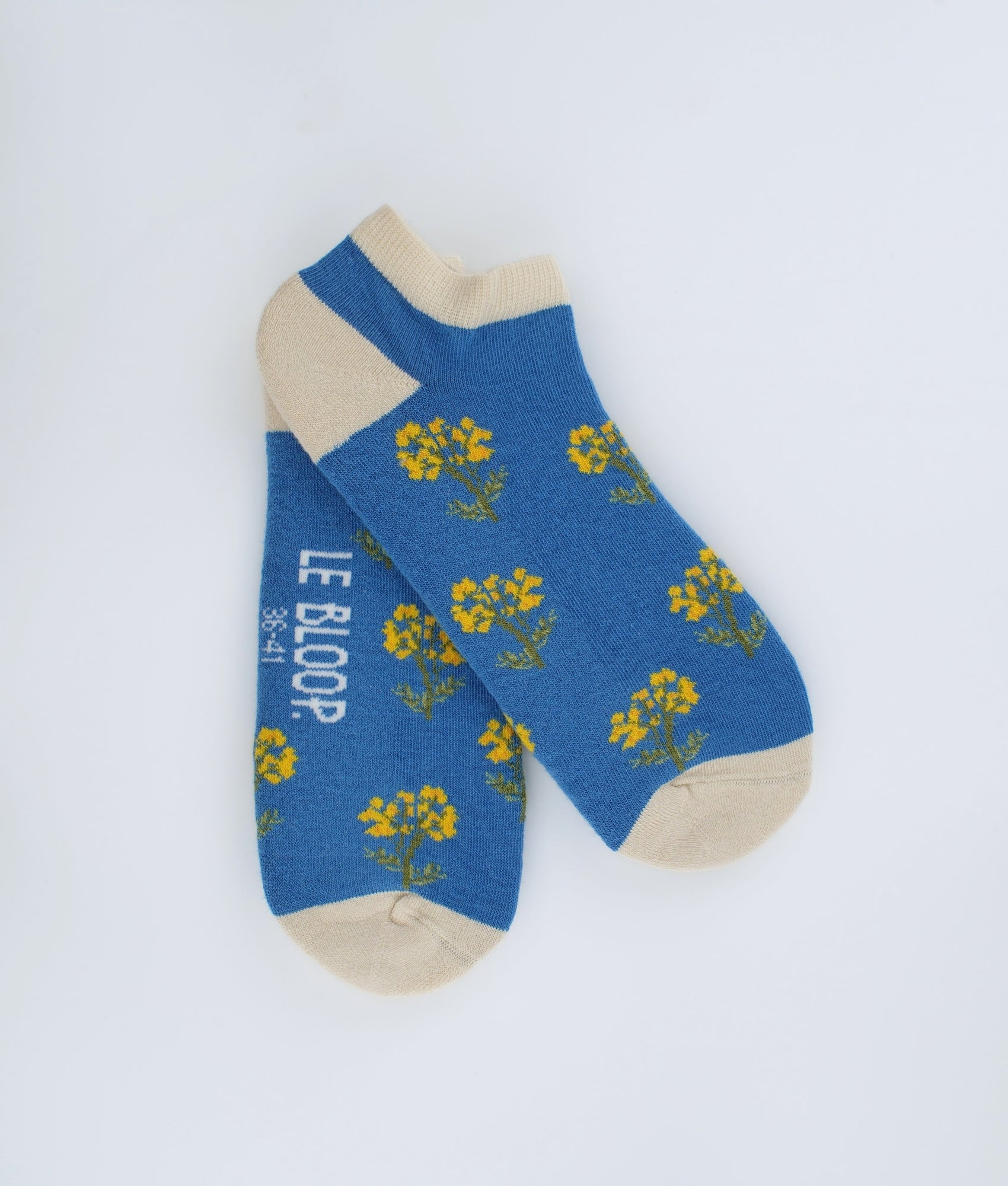 Socquettes fantaisie bleues à motif de fleurs immortelles. Confectionnées en Europe en coton biologique, elles offrent une sensation de douceur et un style floral inspiré de la nature.