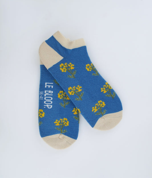 Socquettes fantaisie bleues à motif de fleurs immortelles. Confectionnées en Europe en coton biologique, elles offrent une sensation de douceur et un style floral inspiré de la nature.