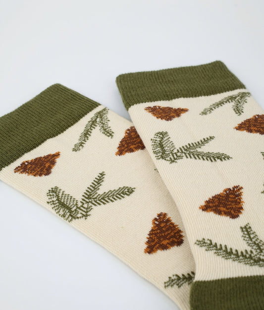Chaussettes fantaisie kaki et beige à motif de pommes de pin. En coton biologique et tricotées en Europe, elles offrent un confort durable et un style inspiré de la nature.