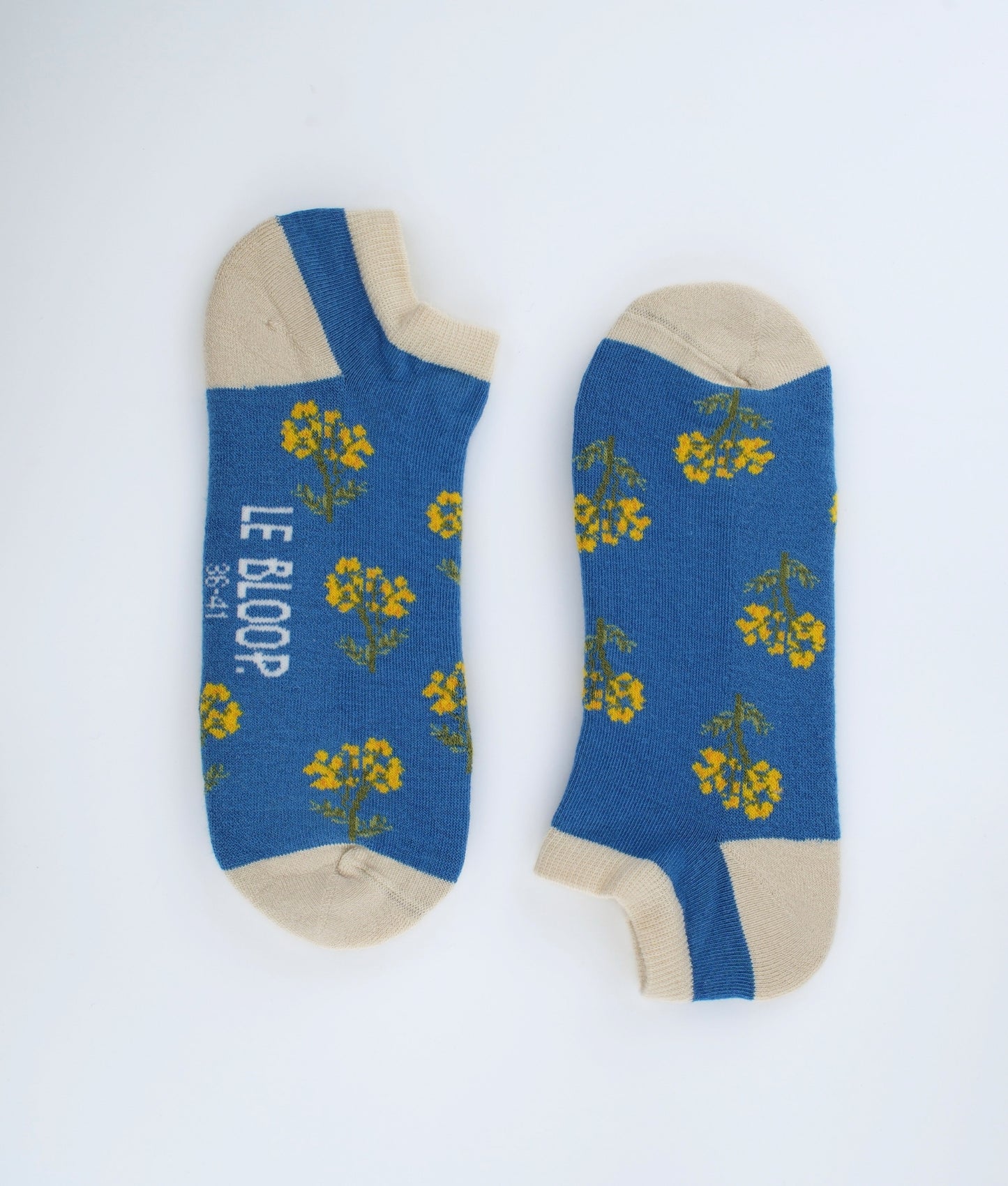 Socquettes fantaisie bleues à motif de fleurs immortelles. Confectionnées en Europe en coton biologique, elles offrent une sensation de douceur et un style floral inspiré de la nature.