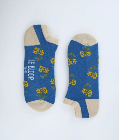Socquettes fantaisie bleues à motif de fleurs immortelles. Confectionnées en Europe en coton biologique, elles offrent une sensation de douceur et un style floral inspiré de la nature.