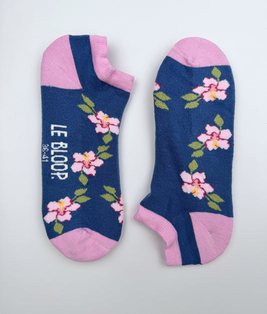 Socquettes fantaisie à motif de roses trémières. Fabriquées en Europe en coton biologique, elles célèbrent l'esprit des jardins de bord de mer avec confort, douceur et originalité.