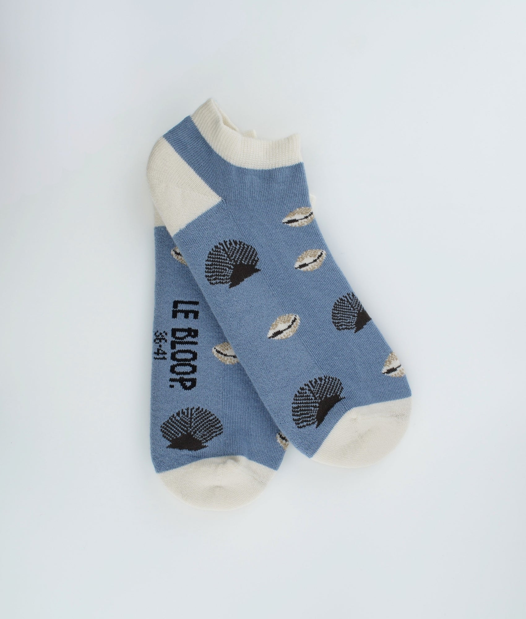 Socquettes fantaisie à motif de coquillages inspirés du bord de mer. Confectionnées en Europe en coton biologique, elles allient légèreté, confort et une touche estivale pleine d’originalité.