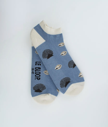 Socquettes fantaisie à motif de coquillages inspirés du bord de mer. Confectionnées en Europe en coton biologique, elles allient légèreté, confort et une touche estivale pleine d’originalité.