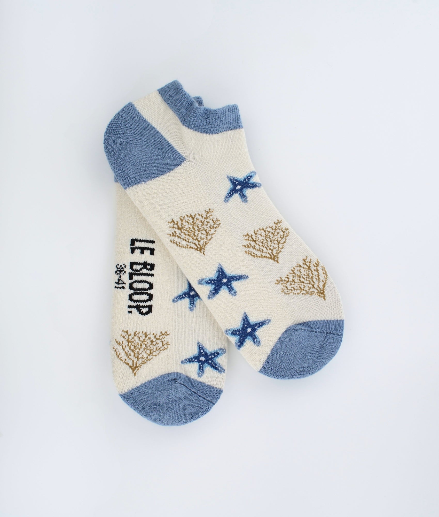 Socquettes fantaisie crème à motif d’étoiles de mer. Fabriquées en Europe en coton biologique, elles apportent une touche marine élégante avec un confort doux et agréable au quotidien.
